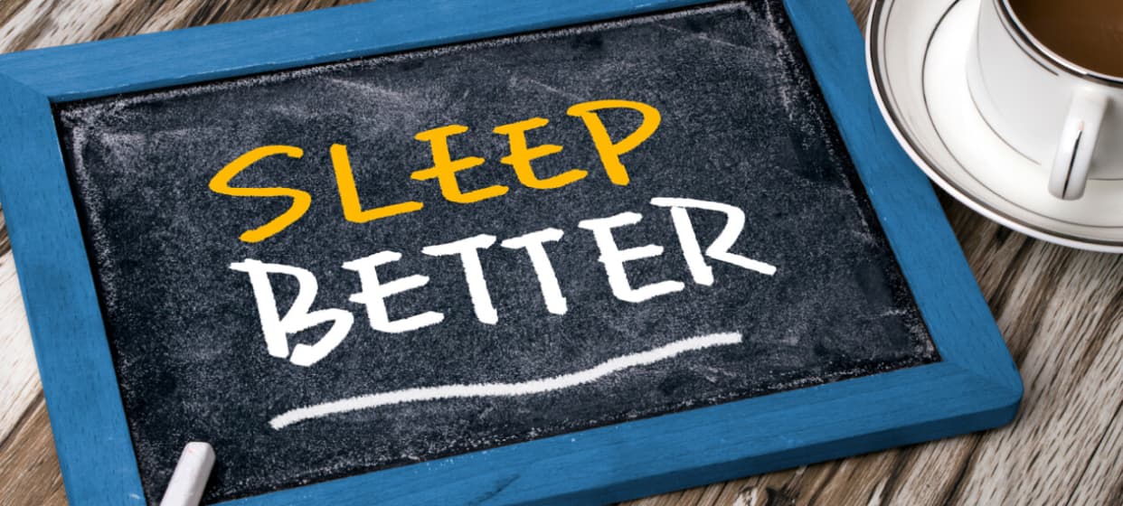 A picture of black bloard with text reading "SLEEP BETTER."